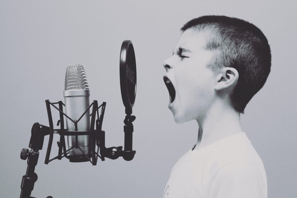 Boy shouting into microphone as a metaphor for contacting me